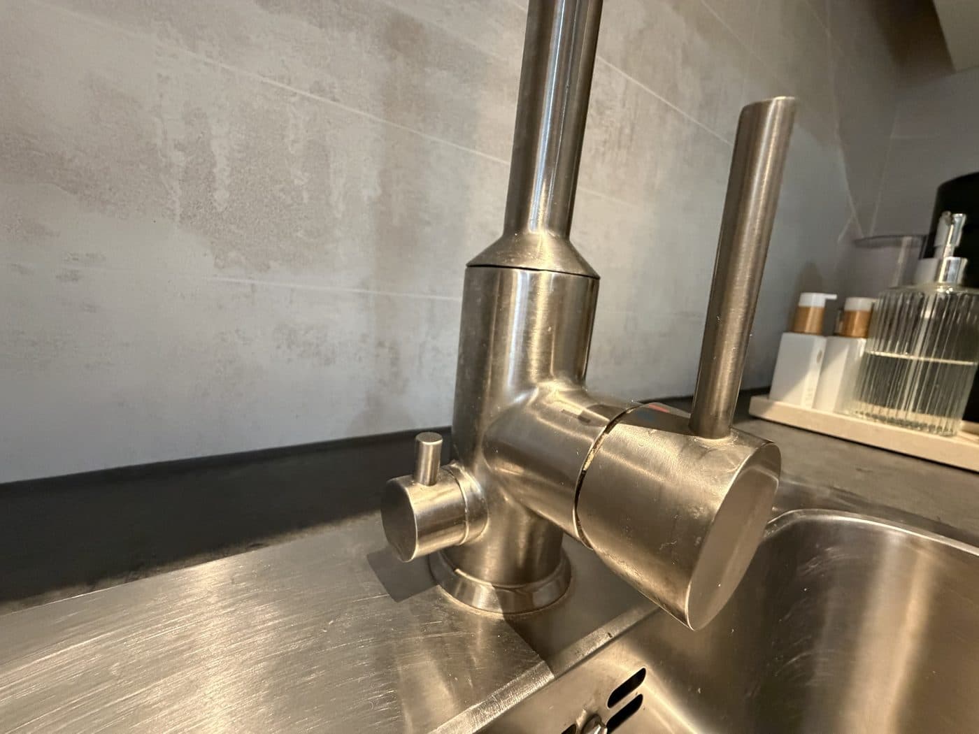 Correct: the small knob left of the faucet points straight up