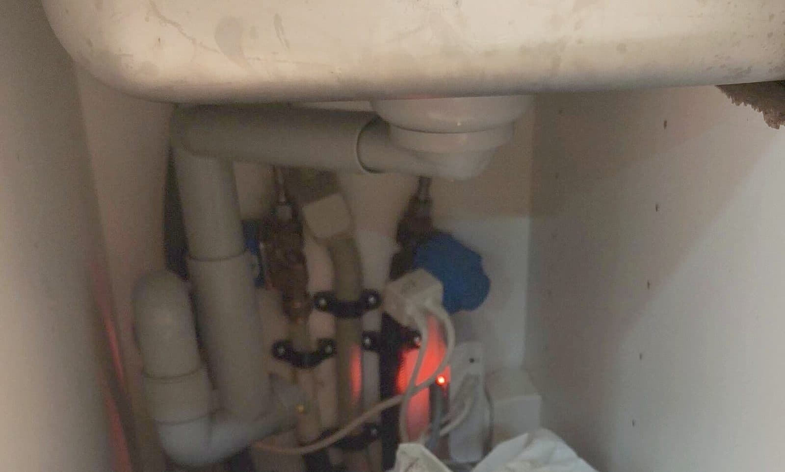 Under the kitchen sink: the water guard glowing red after it has shut off the water